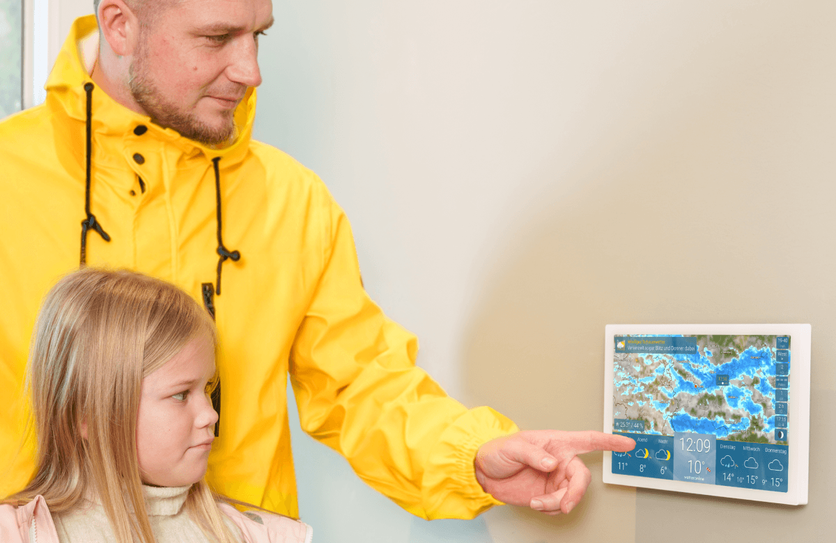 wetteronline home 4 als Wetter Display an der Wand, Vater zeigt Kind die Wettervorhersage mit Regenradar